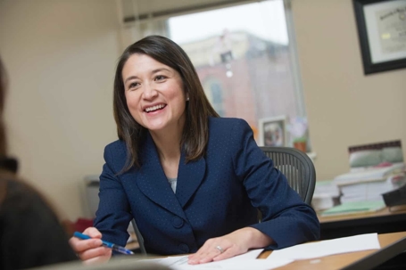 Attorney at law, is smiling across her desk.