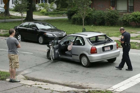 A car accident scene shows a black car and silver hatchback with damage.