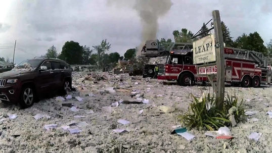 Aftermath of an explosion showing debris and fire trucks