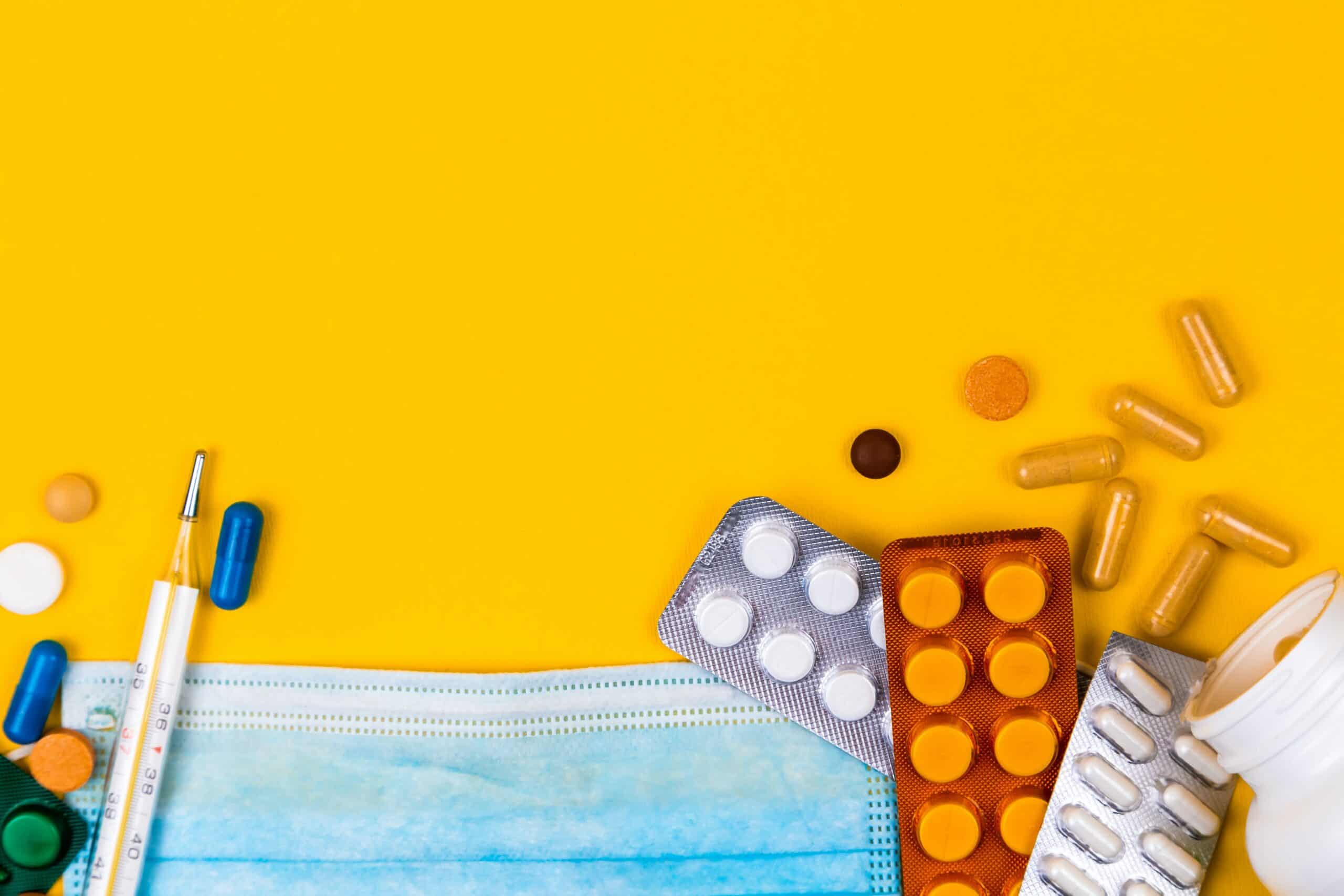 pills-and-a-mask-on-a-yellow-table